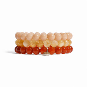 Three beaded wrap bracelets stacked together on a white background, featuring peach, yellow, and orange-red beads with a small silver clasp.