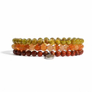 Three beaded stretch bracelets stacked together on a white background, featuring marbled beads in olive green, orange, and reddish-brown, with a small silver metal charm.